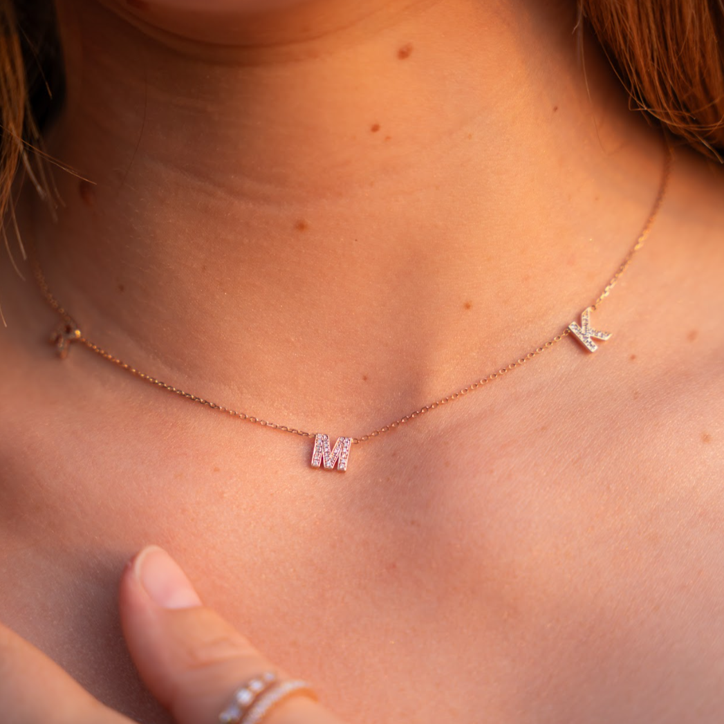 Love Letter necklace with diamond initials on a fine chain worn elegantly, showcasing a certified diamond necklace.