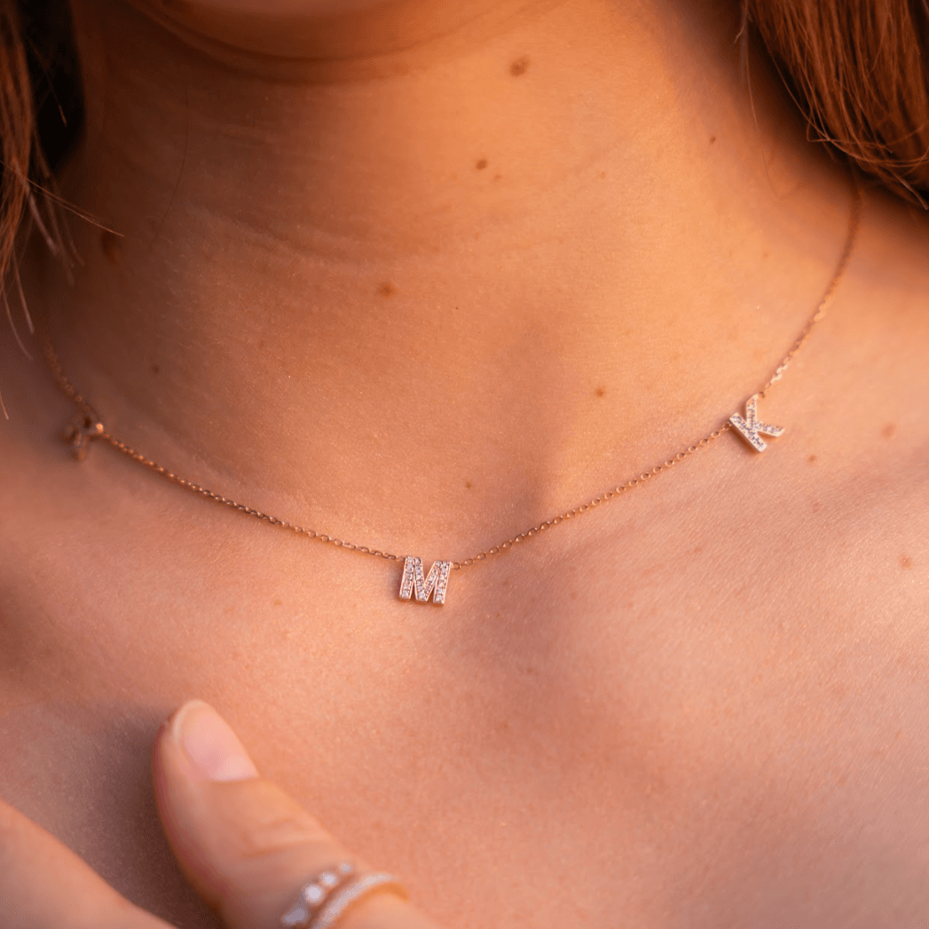 Love Letter necklace with diamond initials on a fine chain worn elegantly, showcasing a certified diamond necklace.