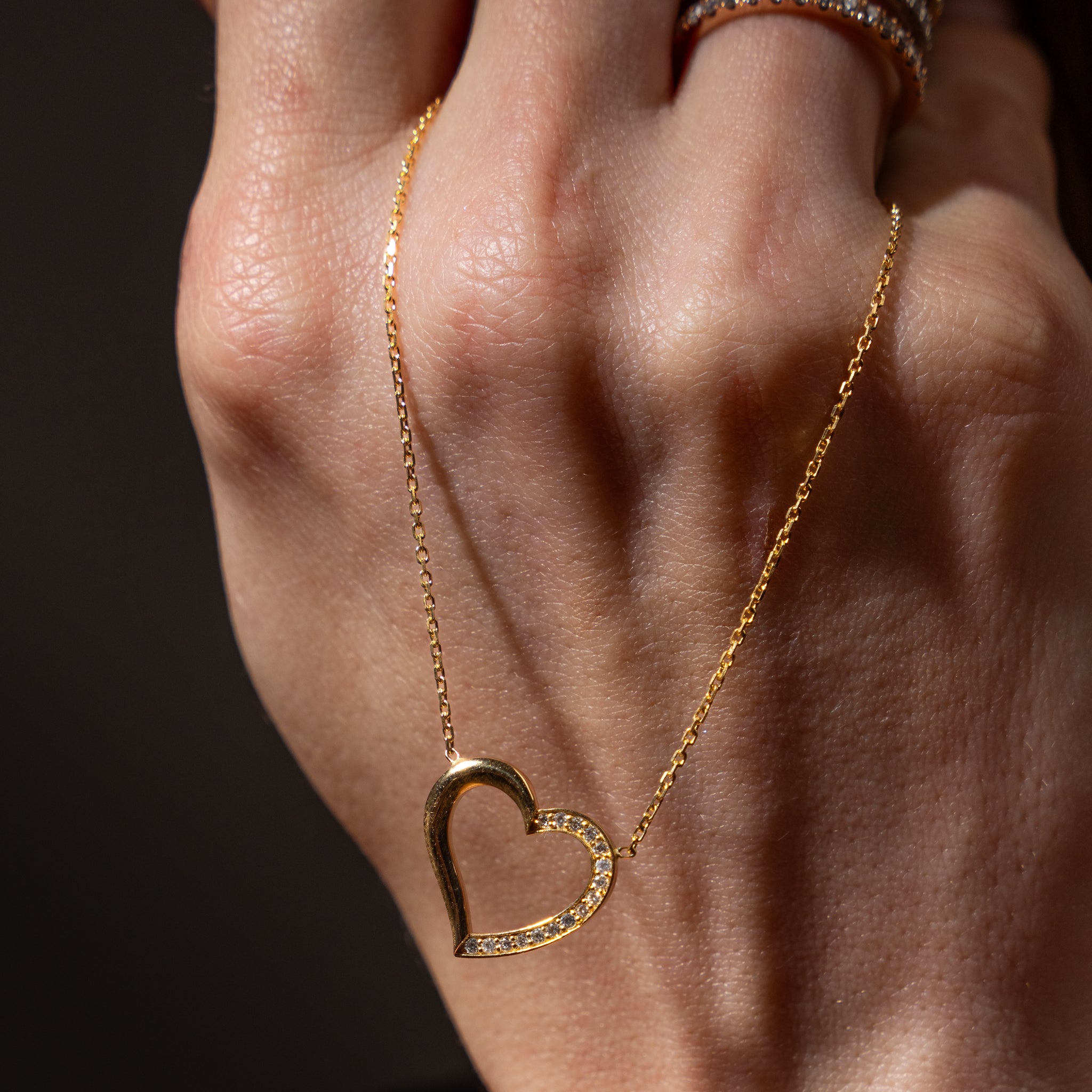 Elegant 18ct gold heart necklace with diamonds, showcasing artistic charm and modern design.