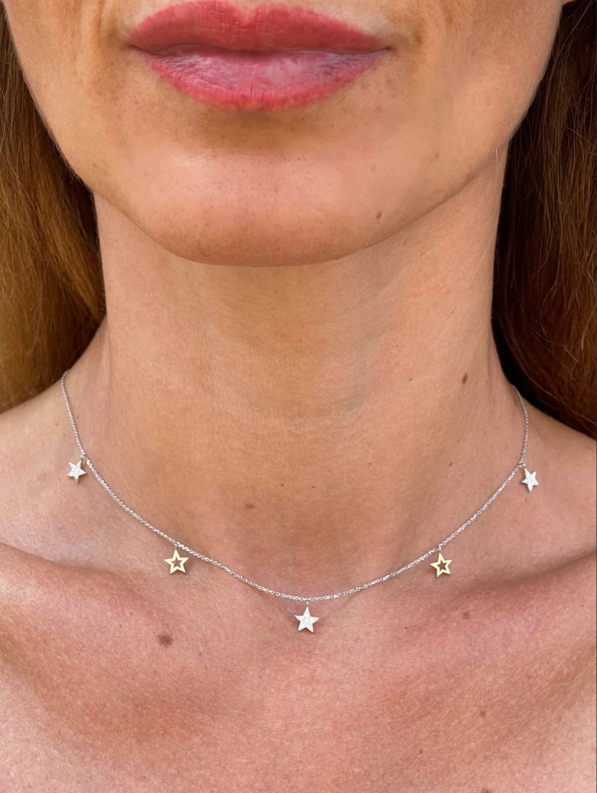 Multi Star Necklace featuring certified diamonds and solid gold stars, elegantly displayed on a woman's neck.