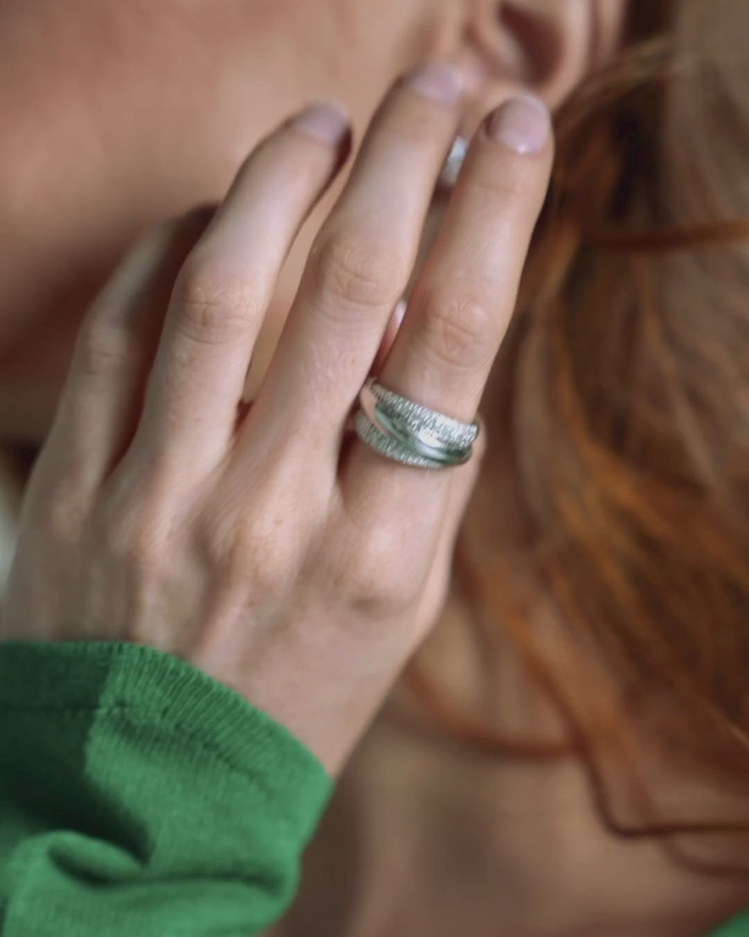 Close-up of a hand wearing The Aurora Ring, a three strand gold and certified diamond ring showcasing elegant sparkle.