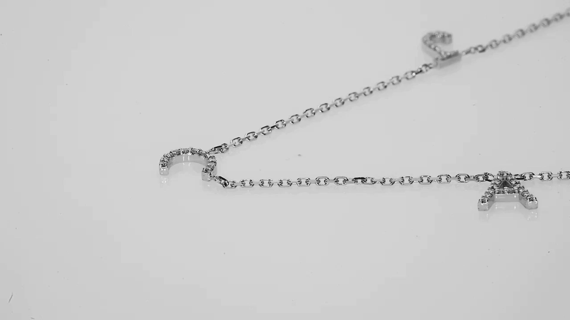 Love Letter necklace featuring natural diamond initials on a fine link chain, showcasing exquisite craftsmanship.