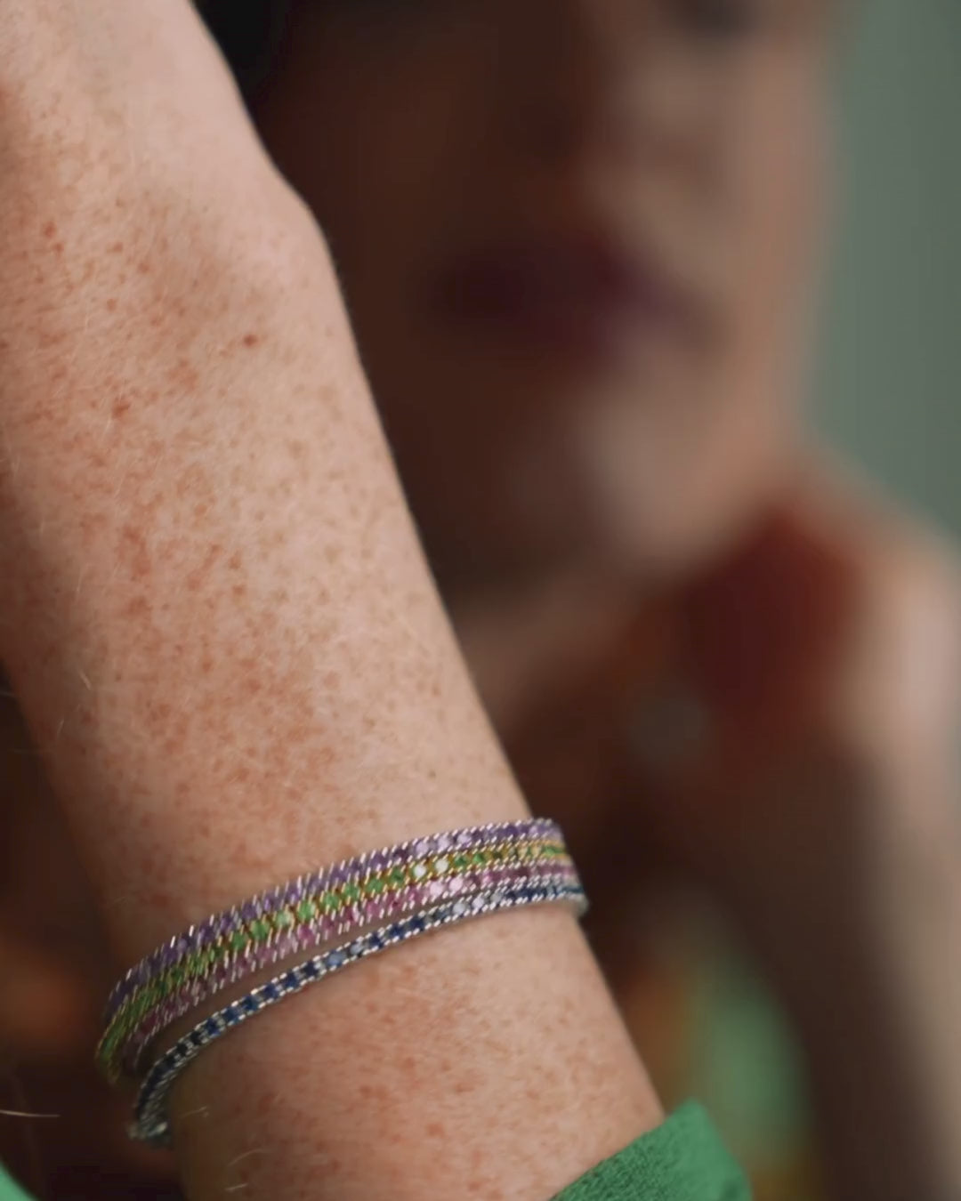 Close-up of a green tsavorite gemstone tennis bracelet worn on a wrist showcasing its vivid colours and elegant design.