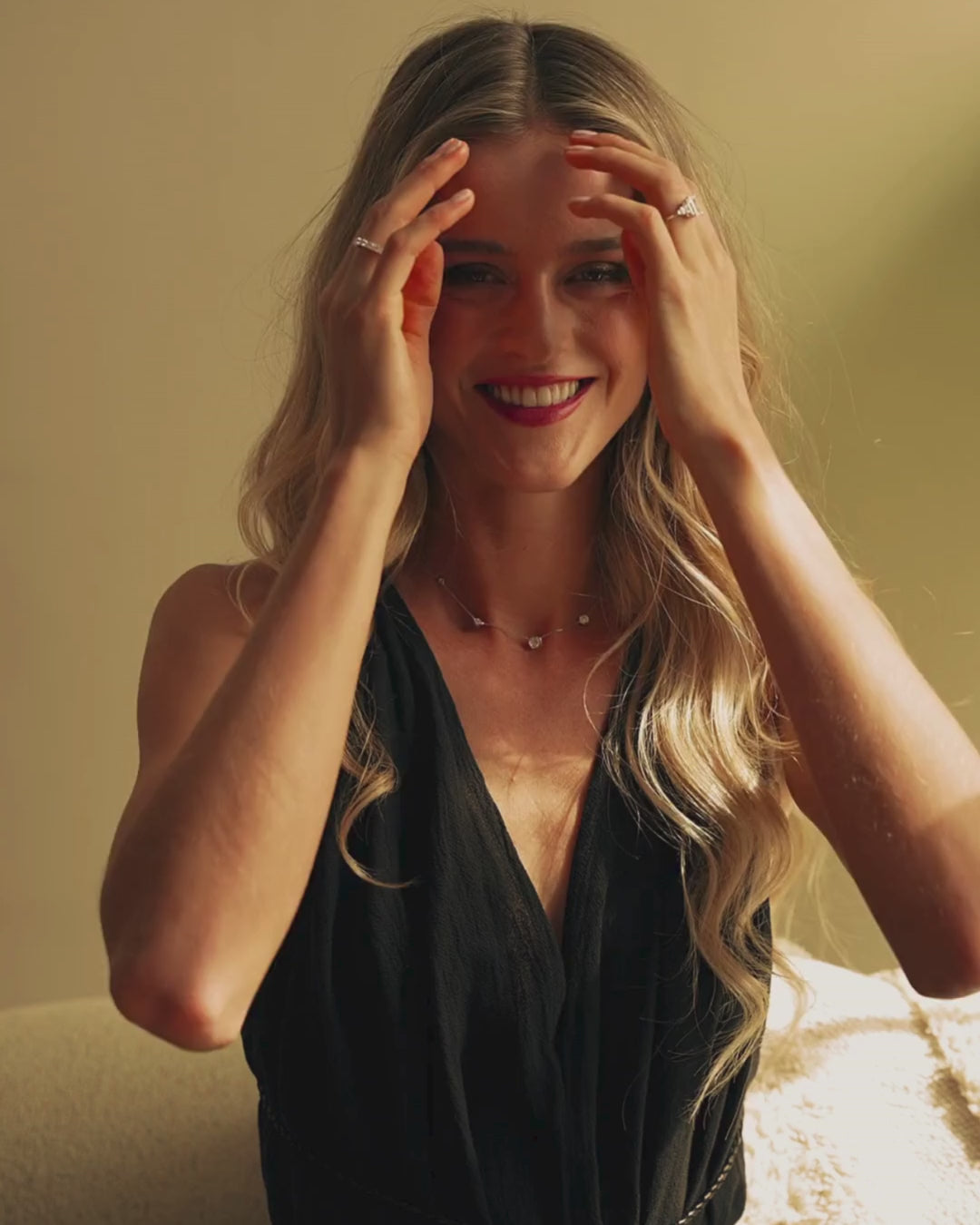 Constellation Necklace - Graduating worn by a smiling model with wavy hair in a stylish black outfit.