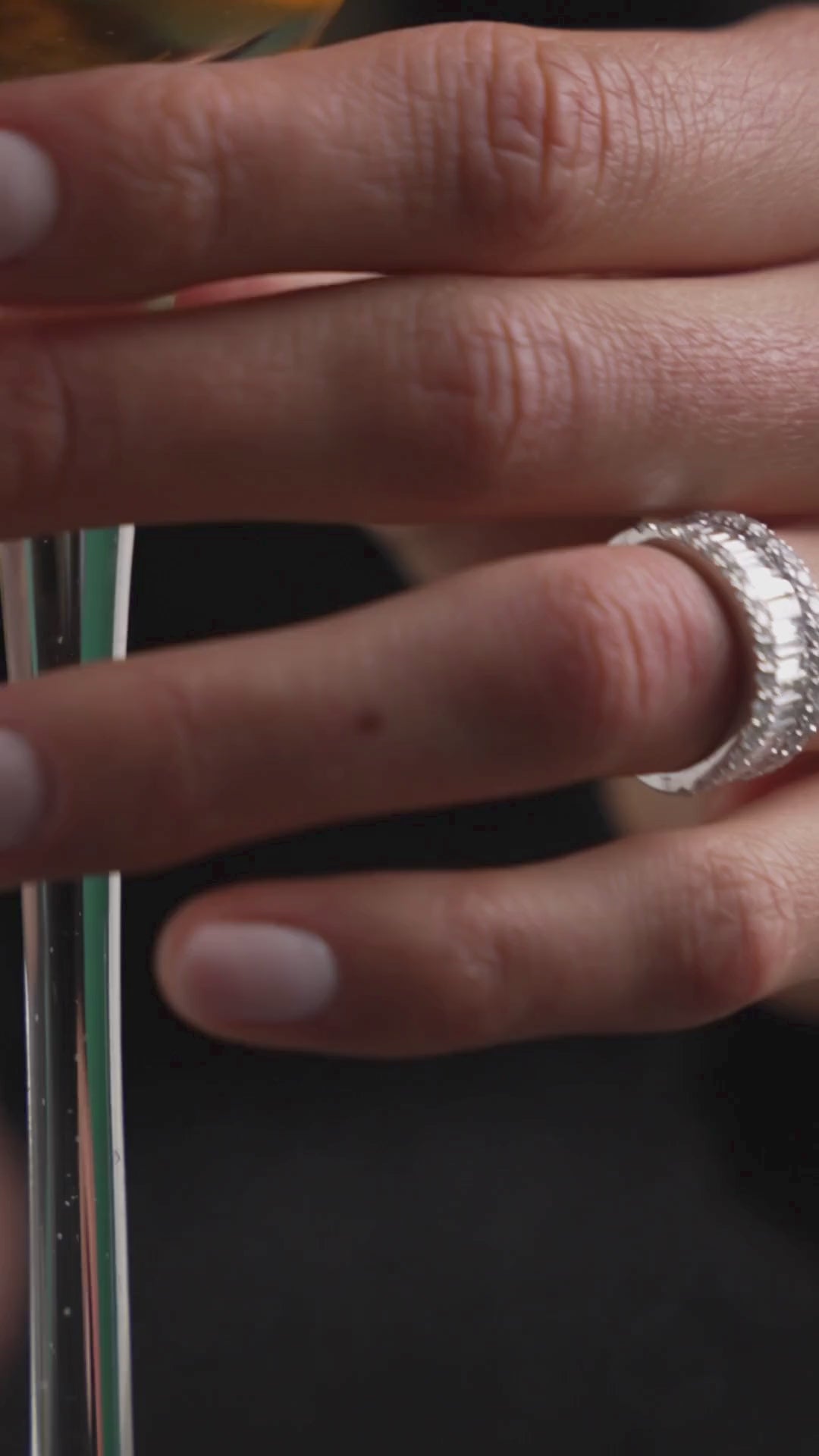 Close-up of a hand wearing a Love Eternity ring with baguette cut diamonds, showcasing its luxury and elegance.