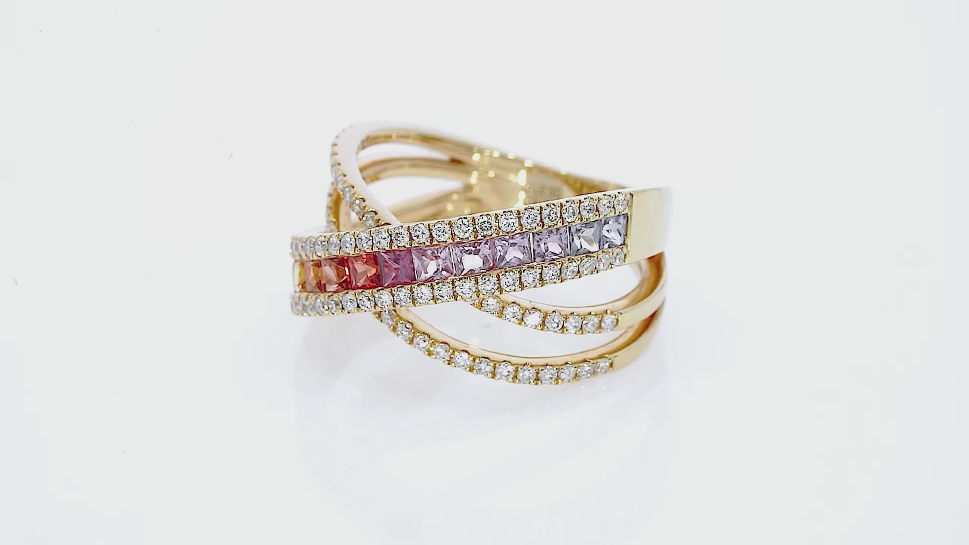 Sapphire Criss cross ring featuring fifteen coloured sapphires, and round brilliant diamonds, set in 18ct gold.