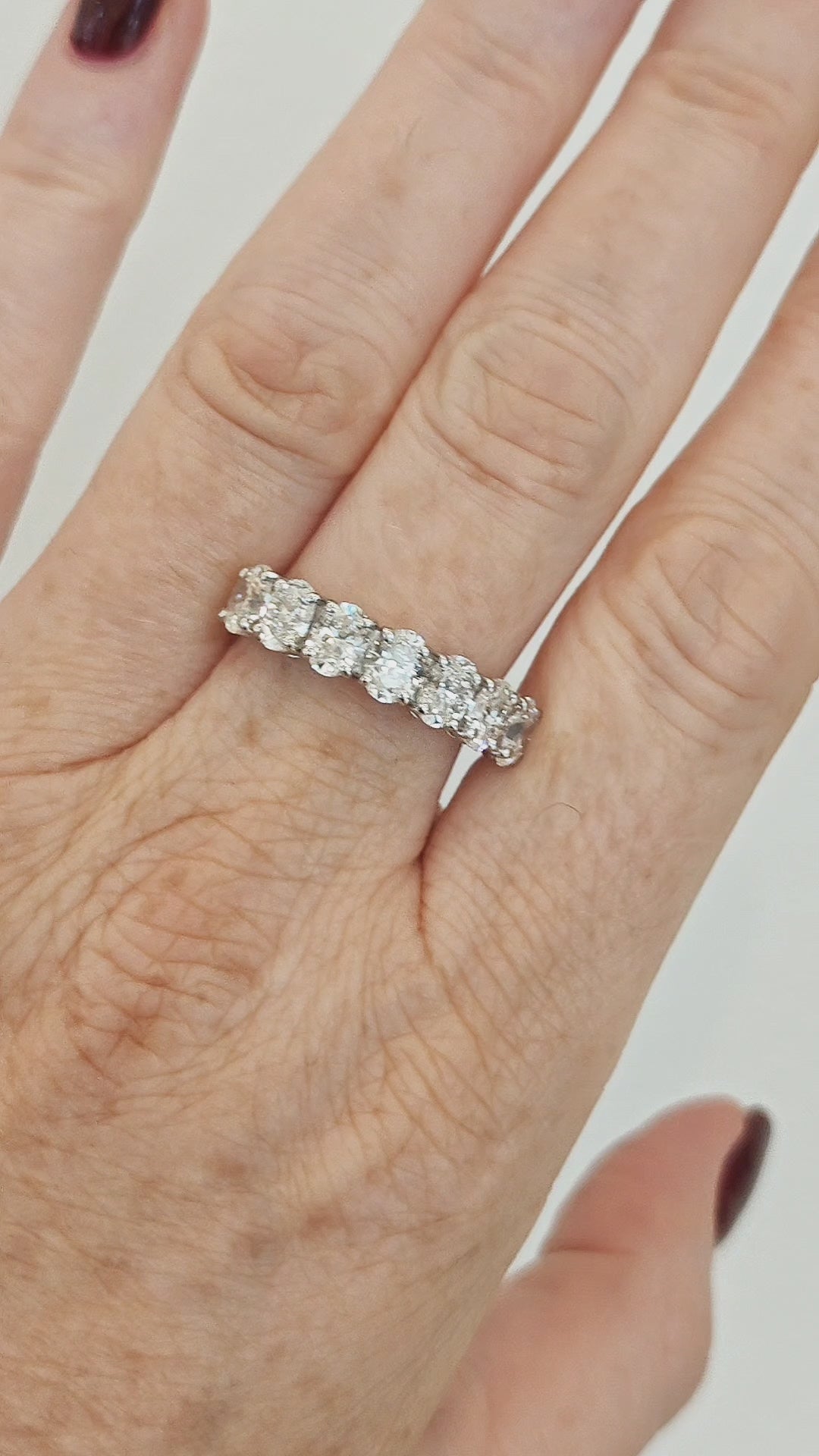 Seven stone oval certified diamond ring showcasing exceptional craftsmanship and detail worn on a hand.