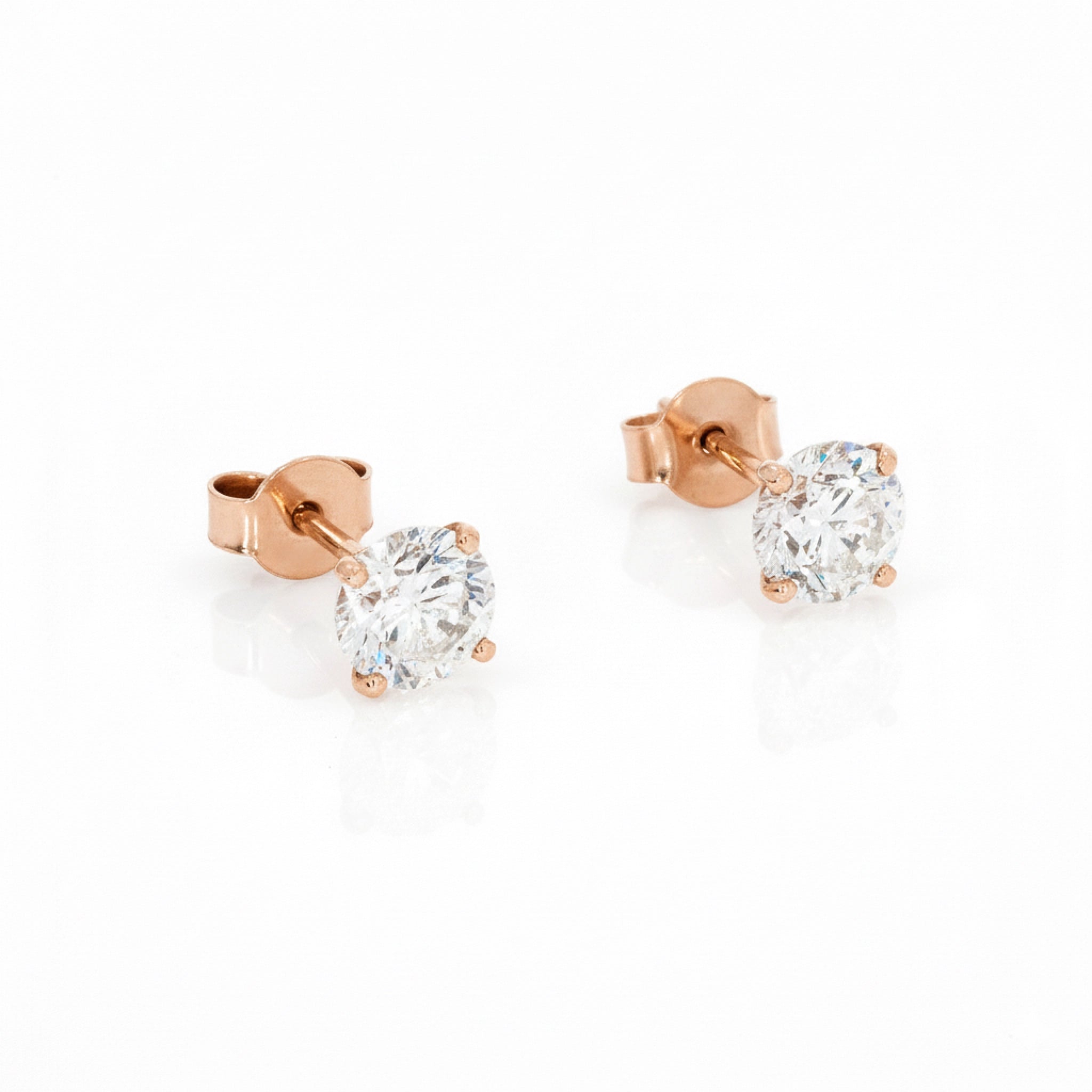 Rose gold stud earrings with diamonds on a white background
