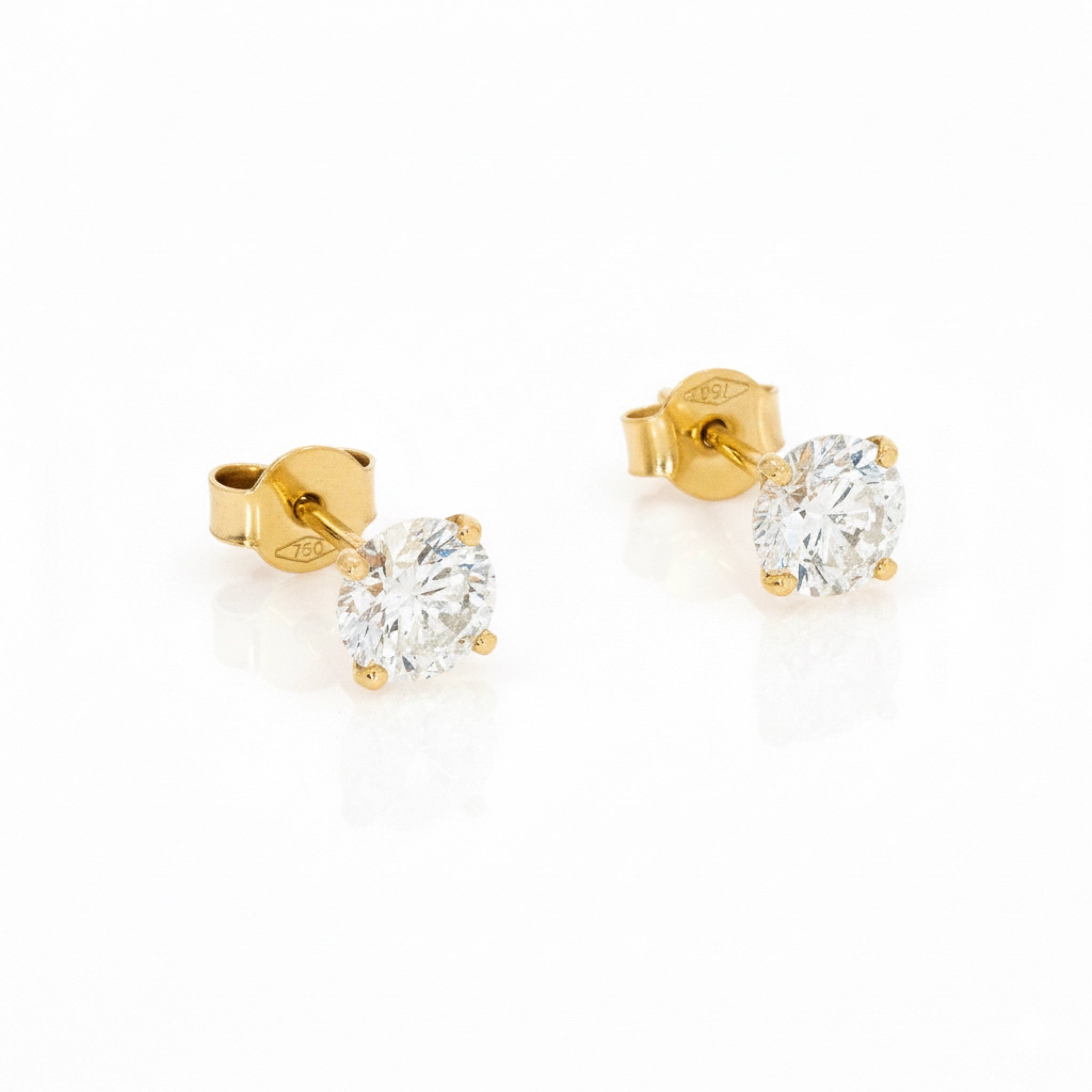 Gold stud earrings with diamonds on a white background