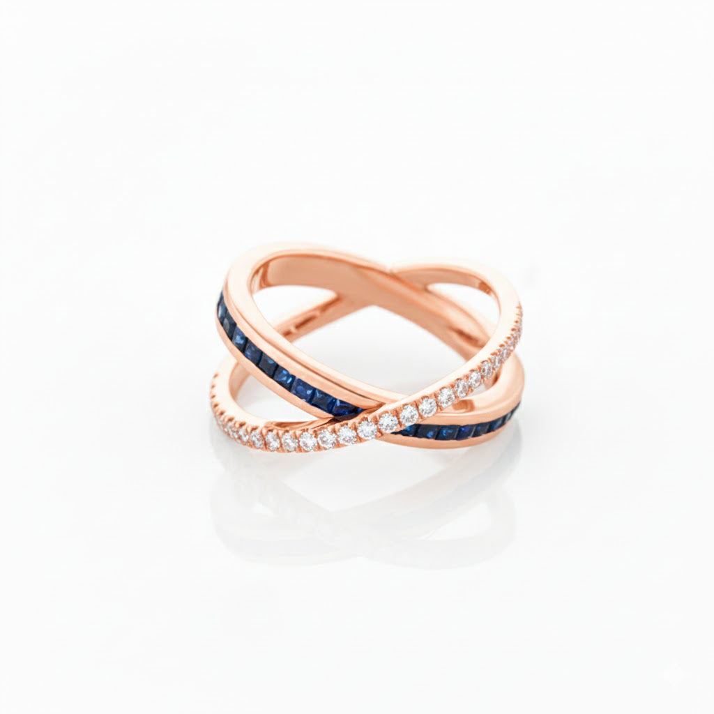 Rose gold criss cross ring with sapphires and diamonds on a white background