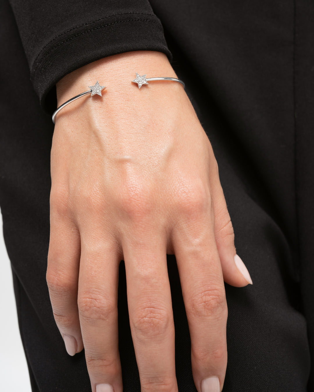 Stylish hand adorned with a certified diamond bracelet Star bangle featuring star accents in white gold.