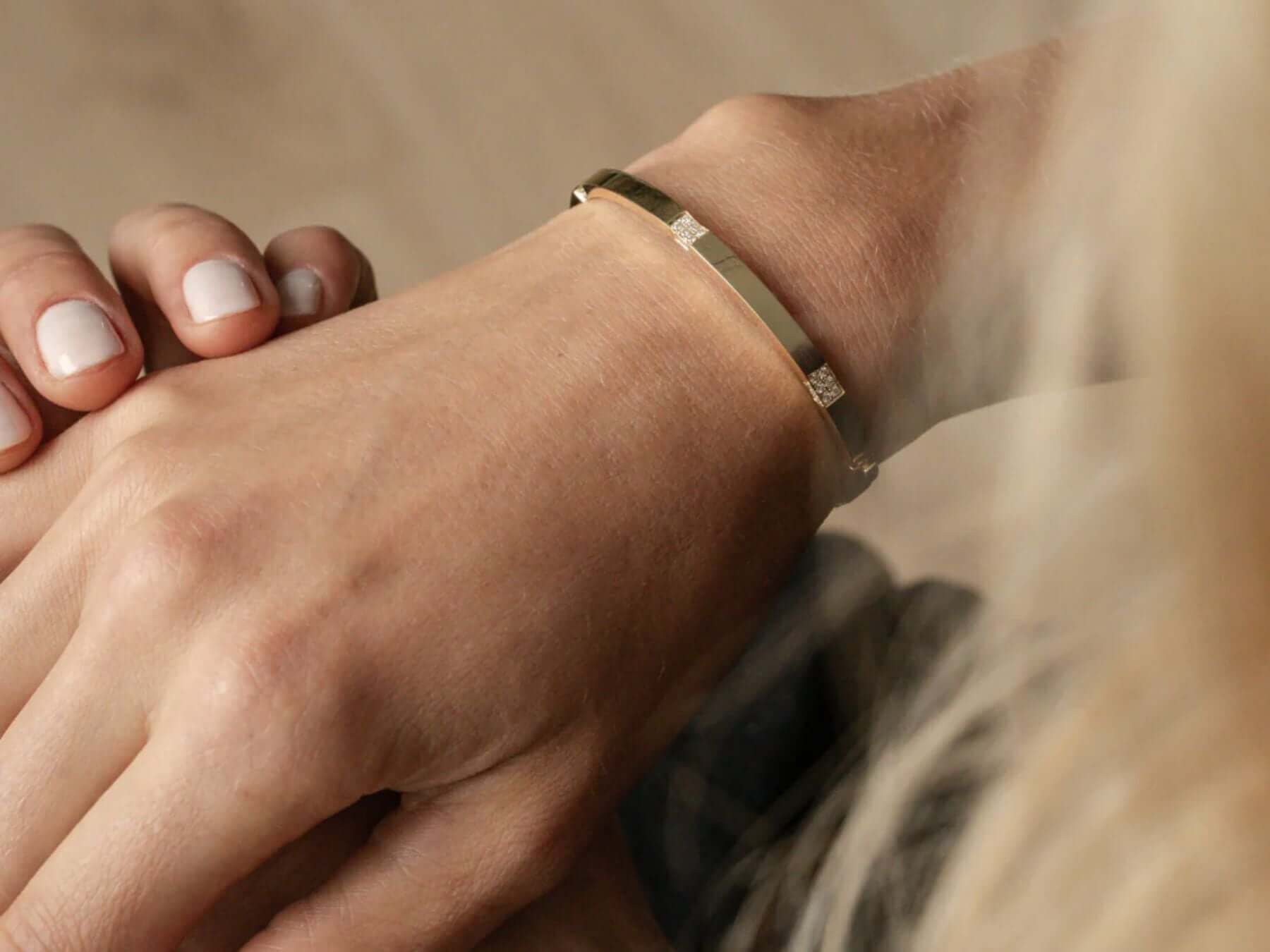 Elegant 18ct gold bracelet on a woman's wrist, showcasing diamond jewellery details.