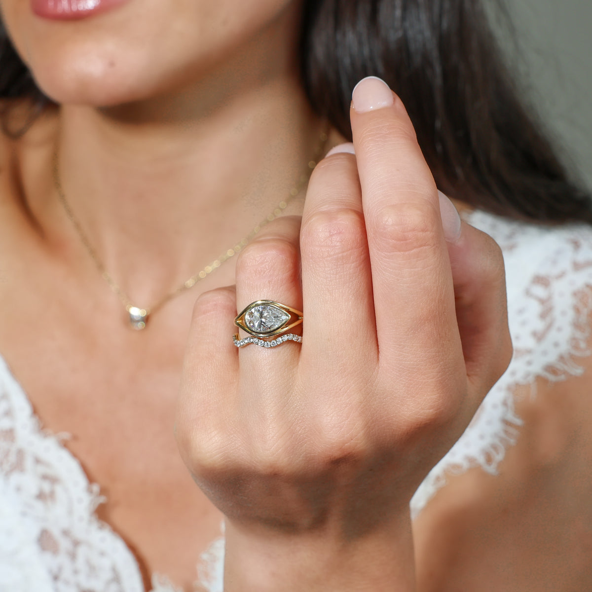 Pear Shaped Ring displayed on a hand, featuring a modern design in yellow gold with a sparkling pear cut diamond.