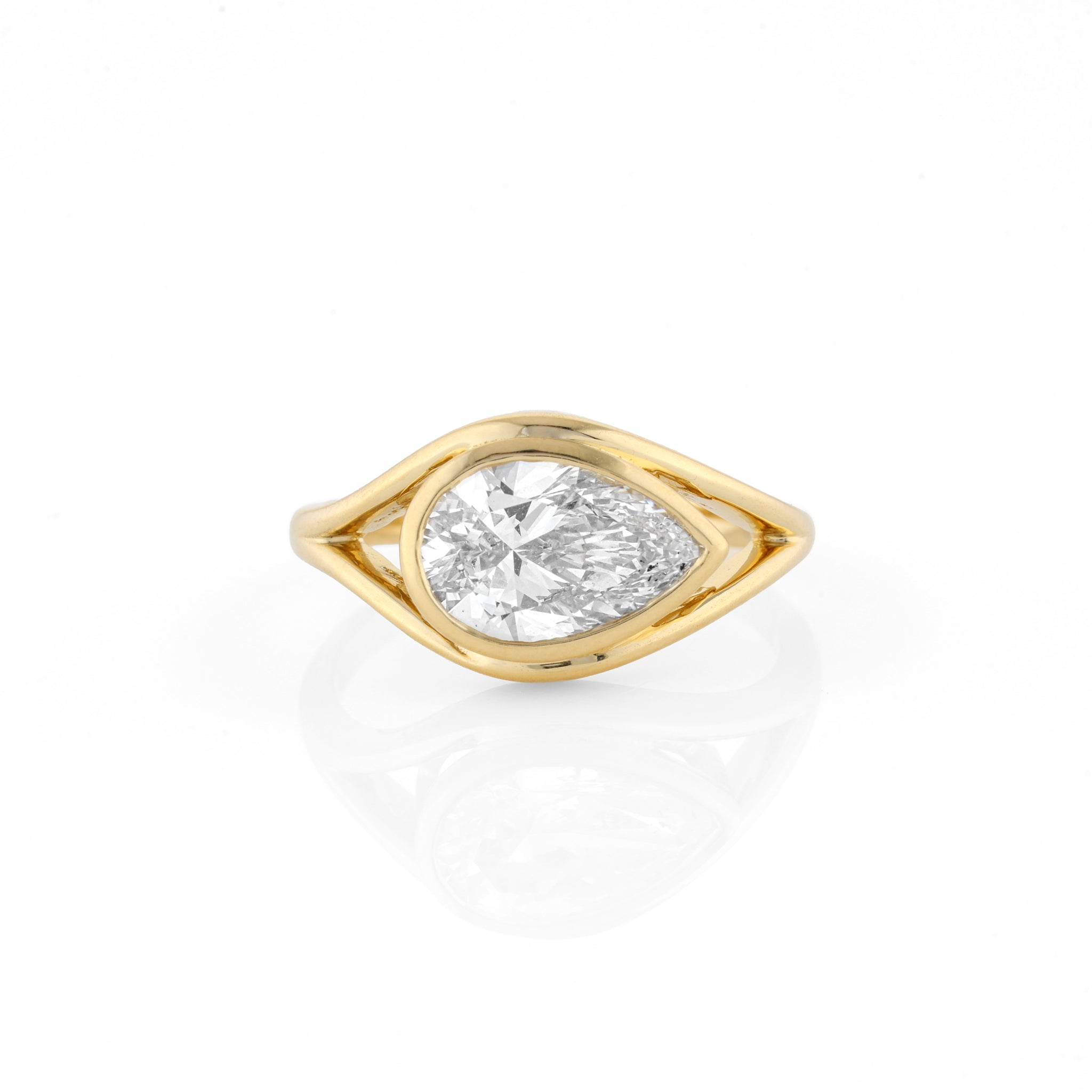 A yellow gold ring featuring a pear cut diamond in a split-shank setting, displayed on a clean white background with a soft reflection below.