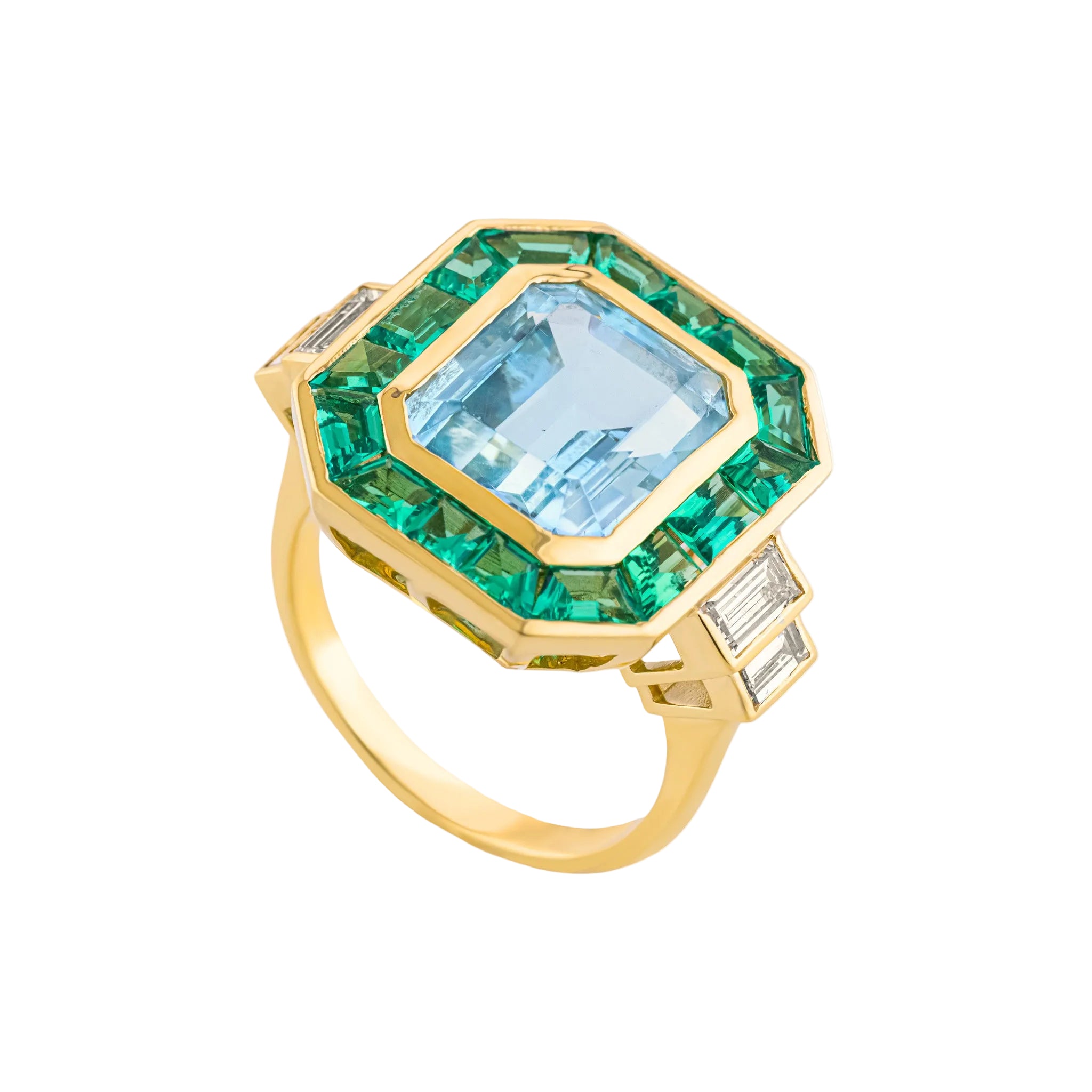 An Art Deco style ring featuring a large light blue topaz gemstone surrounded by a double halo of emerald cut green emeralds, set in a polished yellow gold band with baguette cut side diamonds
