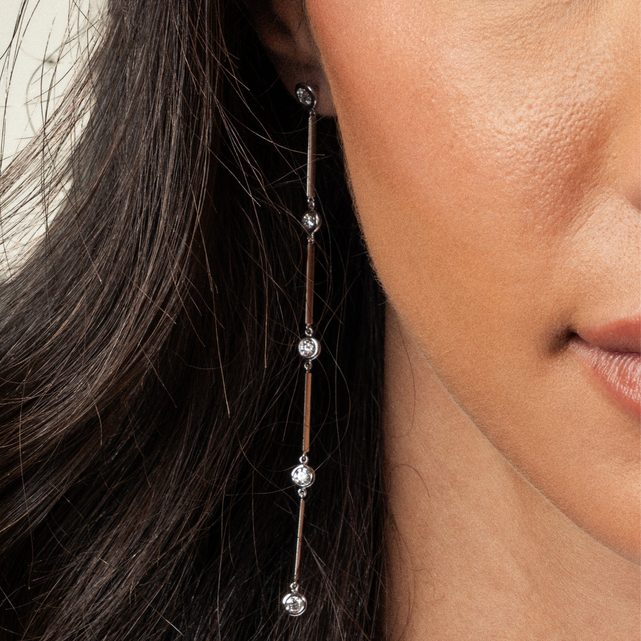Close-up of a model wearing Cascade Diamond earrings in 18ct white gold with a cascading design.