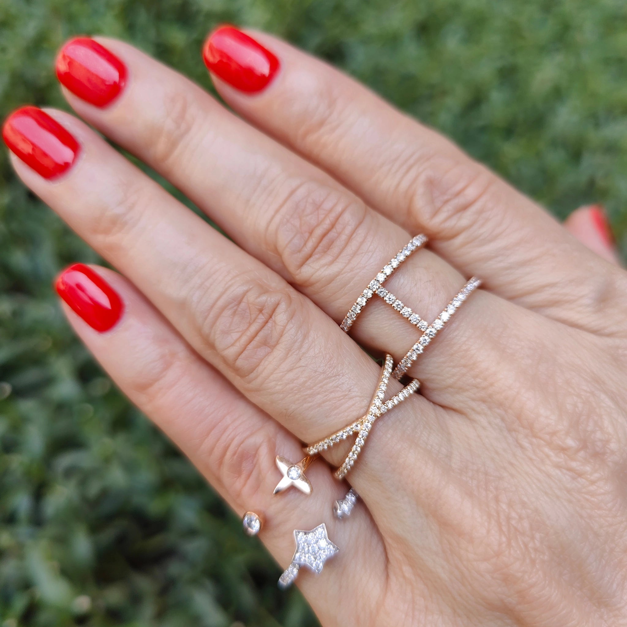 Hand adorned with multiple elegant diamond rings showcasing modern fashion and sparkle.