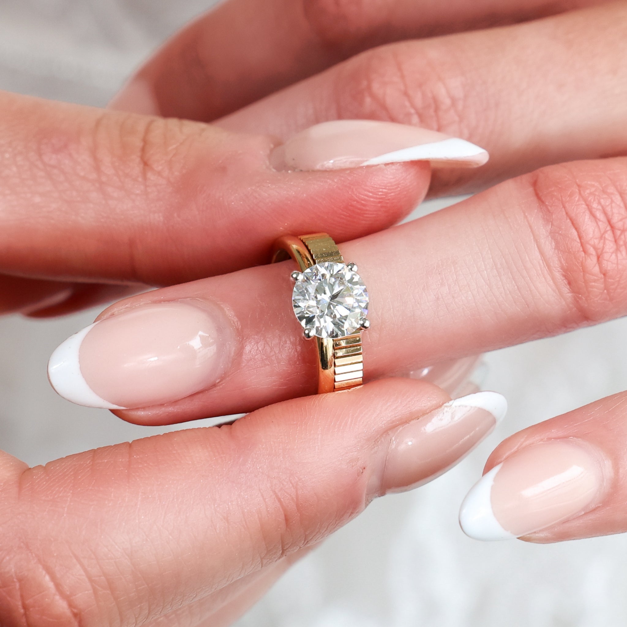 Fluted Wedding Band displayed on a finger, showcasing a diamond ring with a clean, fluted texture and minimalist design.