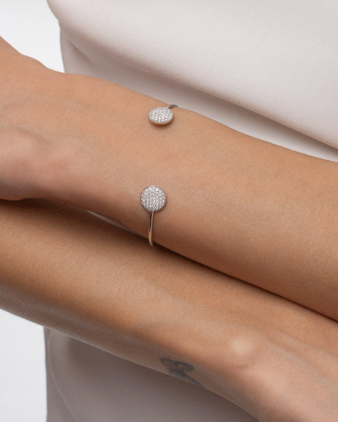 Gemini bangle made with certified diamonds set in gold, featuring round clusters sparkling on a wrist.