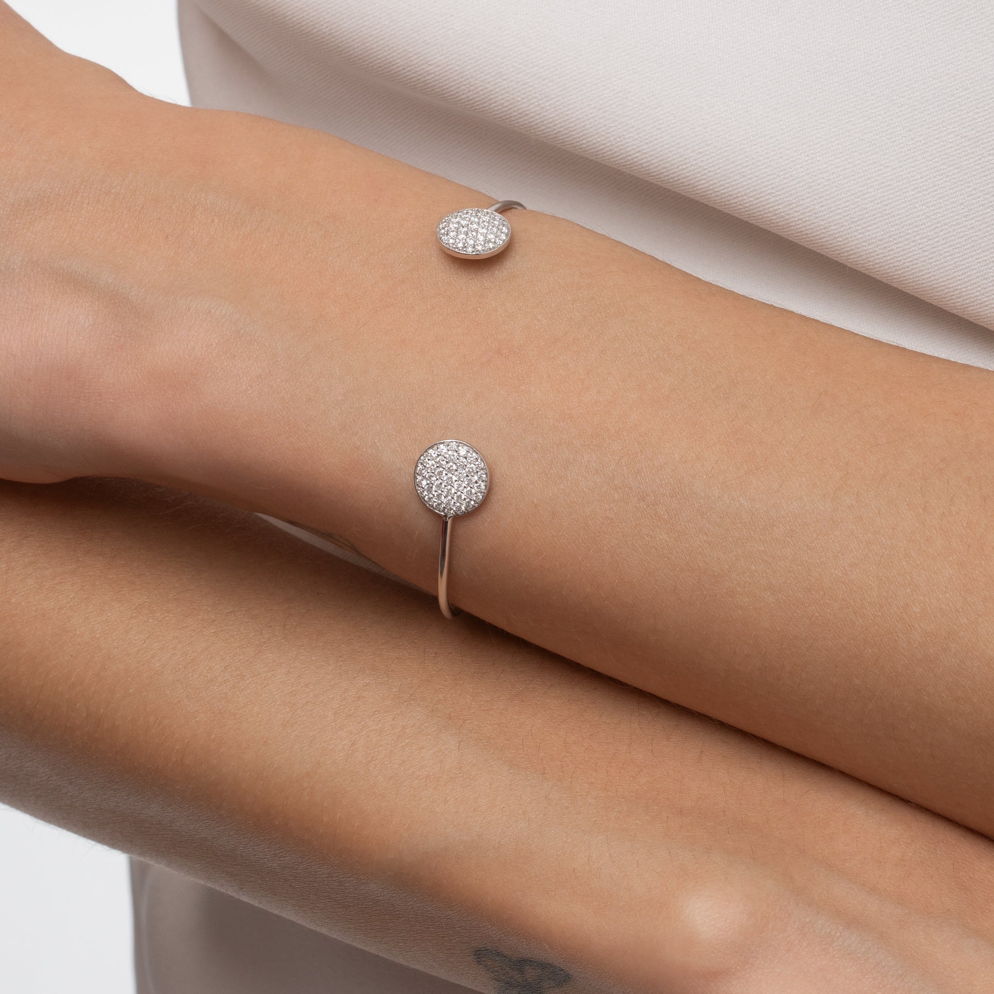 Gemini bangle made with certified diamonds set in gold, featuring round clusters sparkling on a wrist.