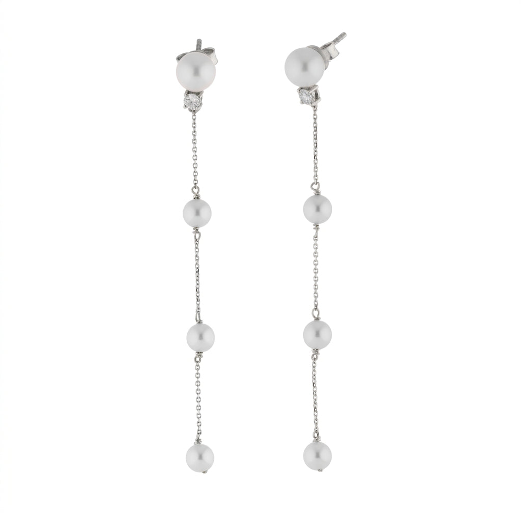 Long pearl drop earring with a single diamond set in 18ct white gold.