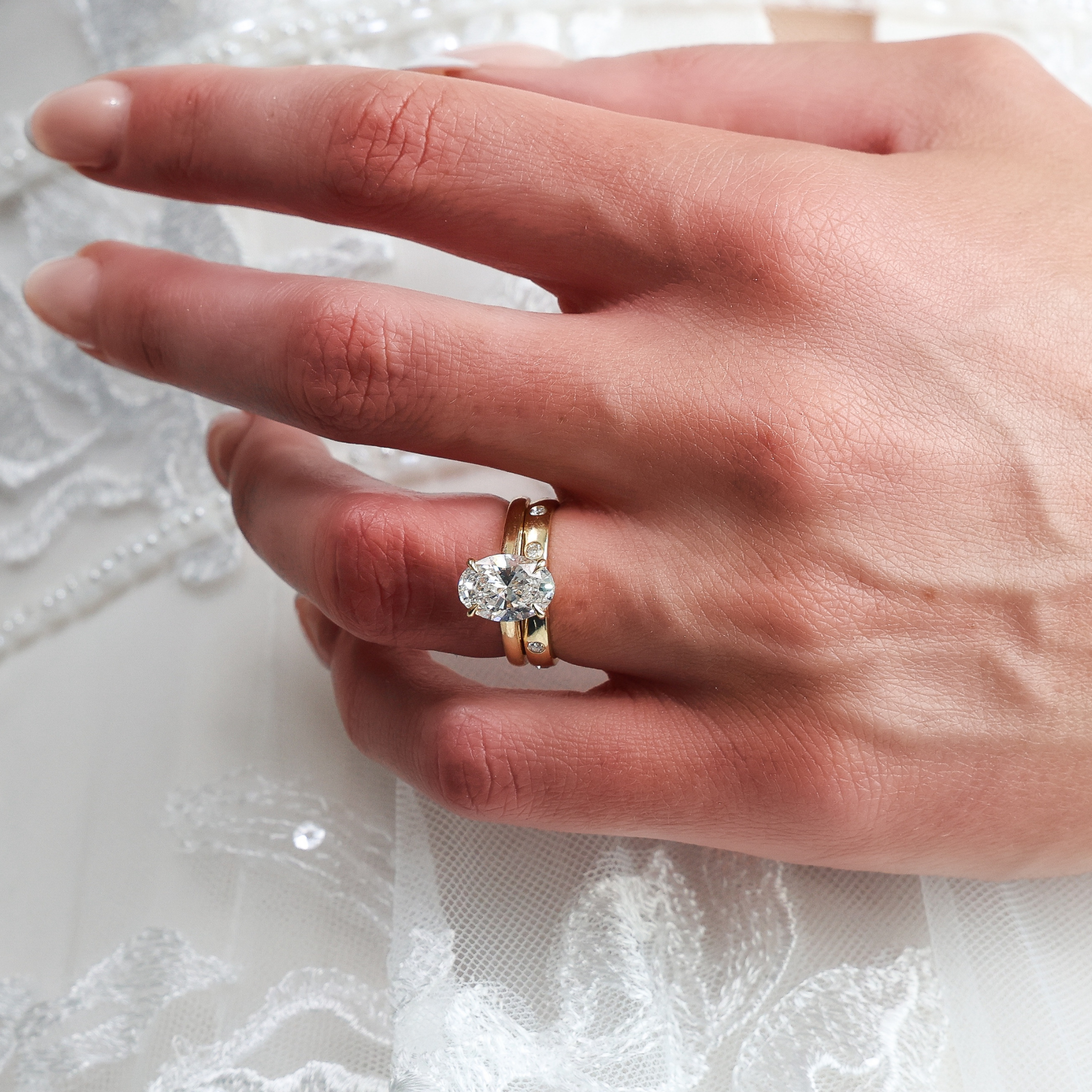 Round Brilliant Cut Diamond Inlay Band displayed on a hand, highlighting its elegant gold design and stunning diamonds.