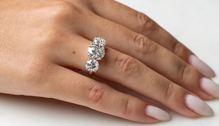 Ring with three diamonds on a hand against a white background