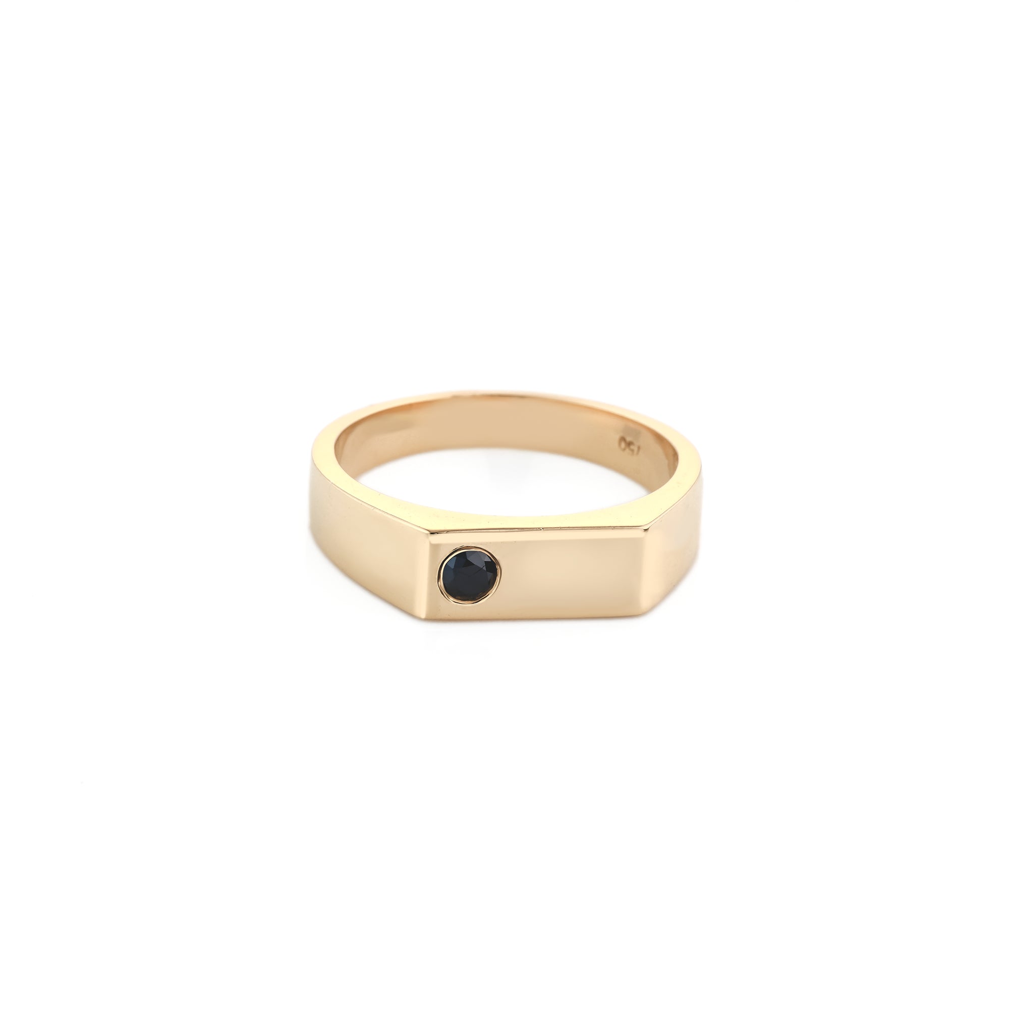 Gold ring with a black gemstone on a white background