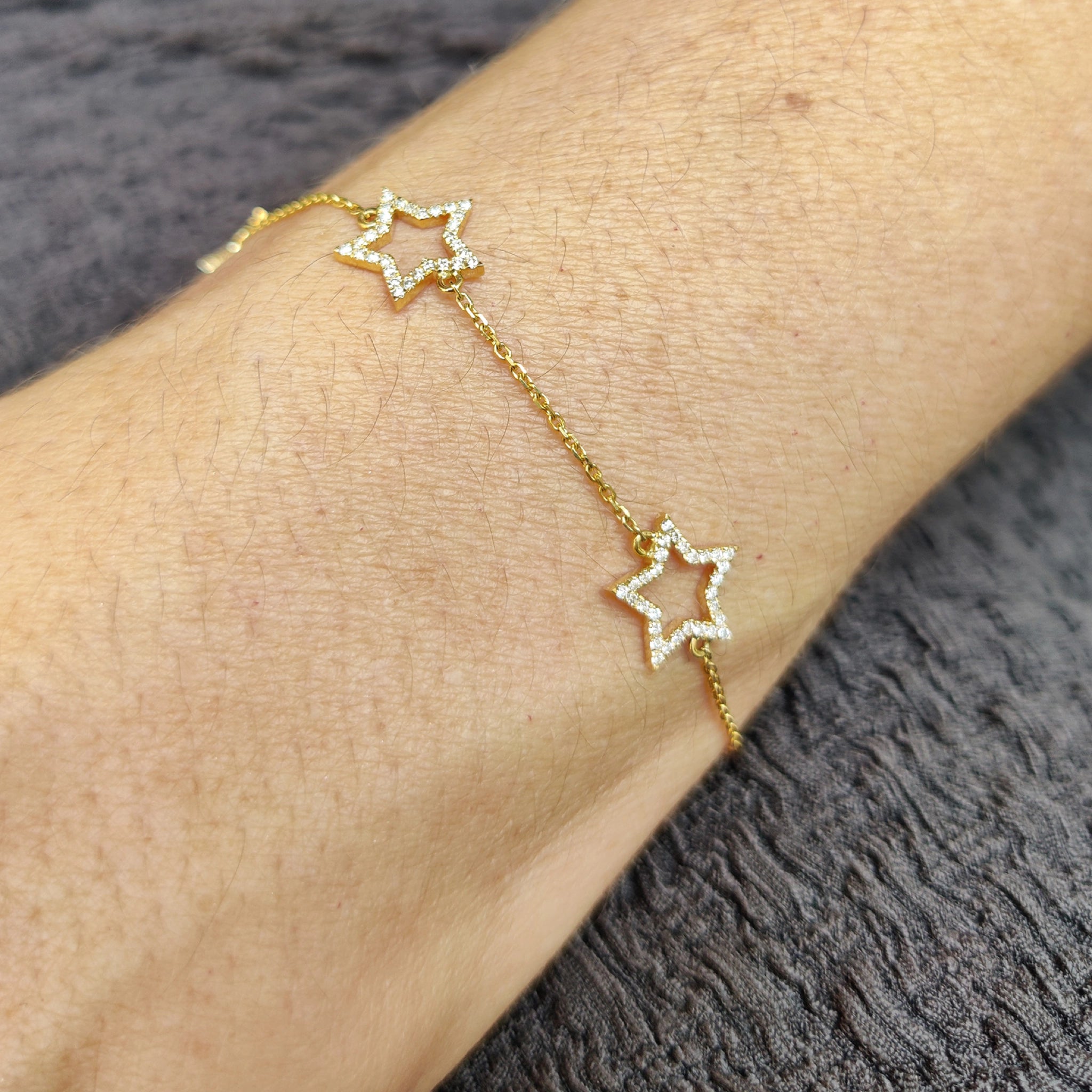 Star bracelet featuring on a delicate gold chain, perfect for a feminine and youthful style.