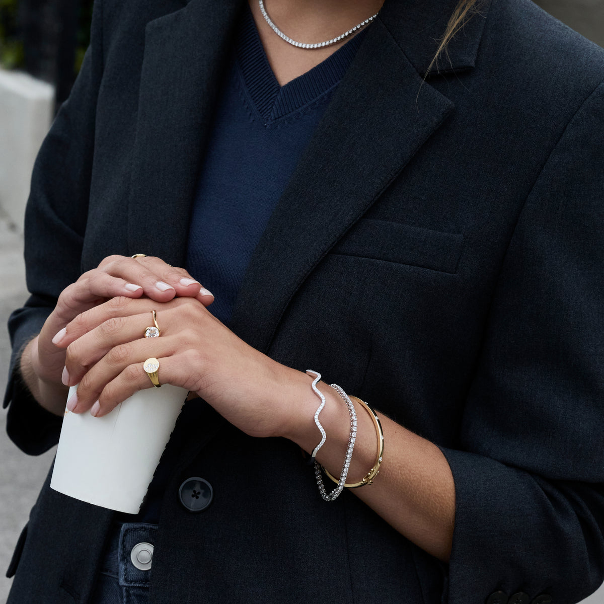 Diamond Wave Bangle styled with gold rings and bracelets, showcasing a sophisticated look with elegant accessories.