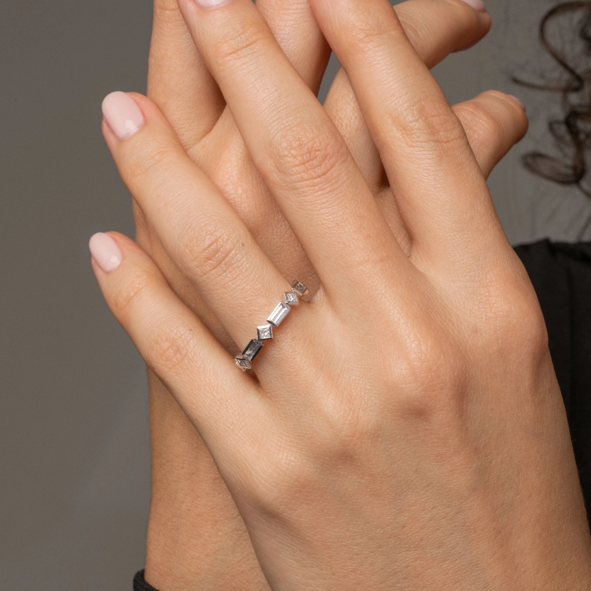 Baguette bezel ring featuring diamond accents elegantly worn on a woman's hand, showcasing its modern design.