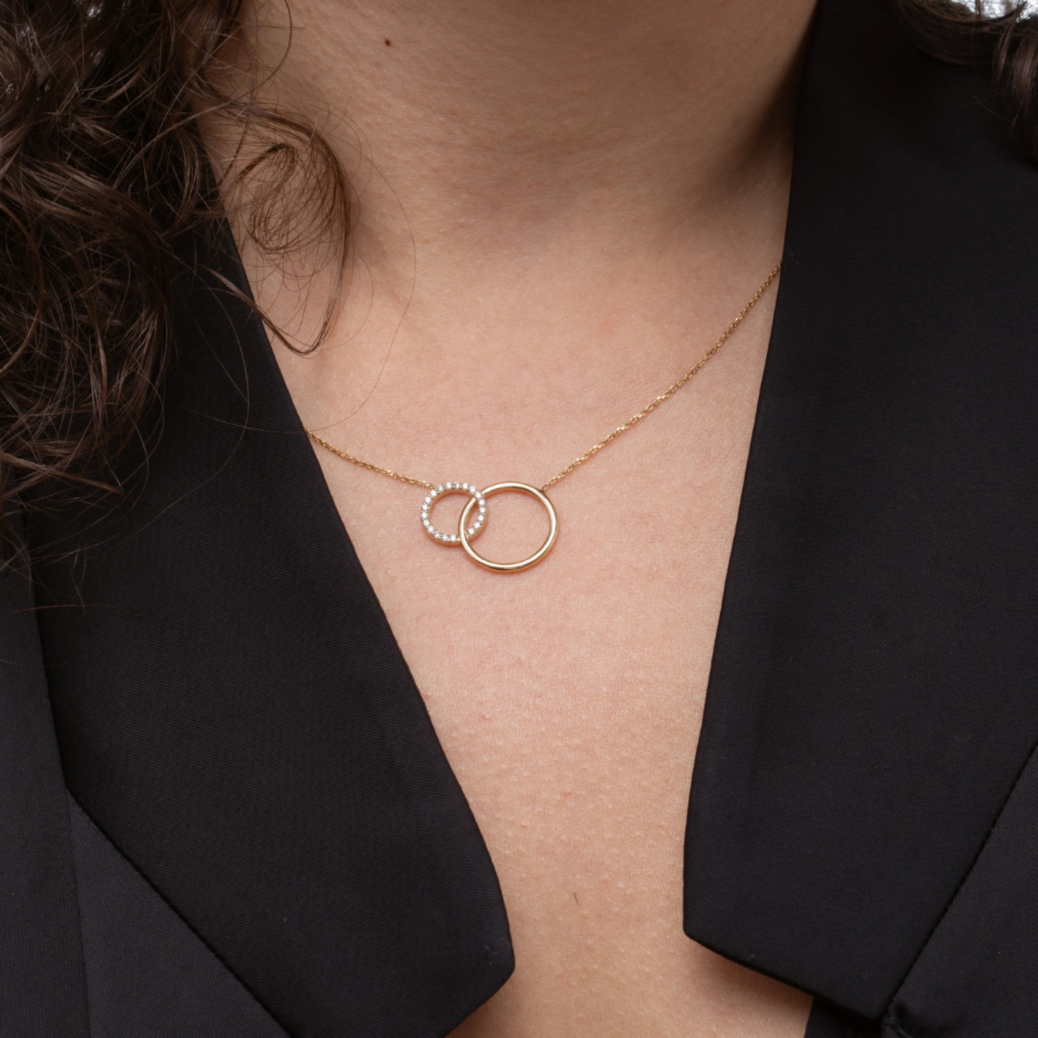 Close view of a circle and sparkle certified diamond necklace with two interlocking circles showcasing bright diamonds.