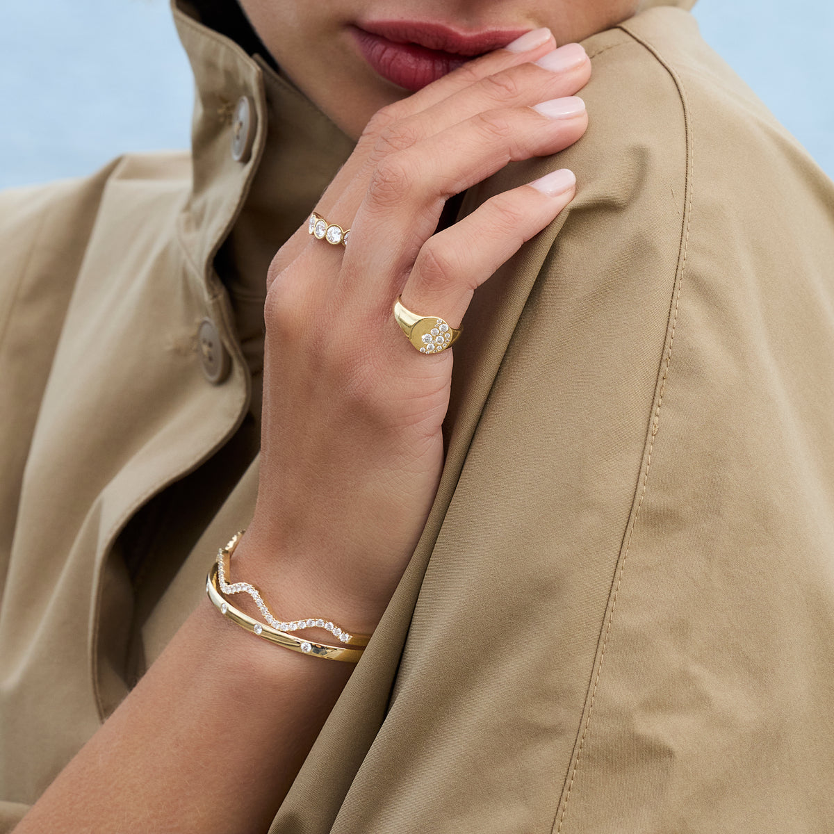 Model showcasing Diamond Wave Bangle in gold with sparkling diamonds, paired with elegant rings.