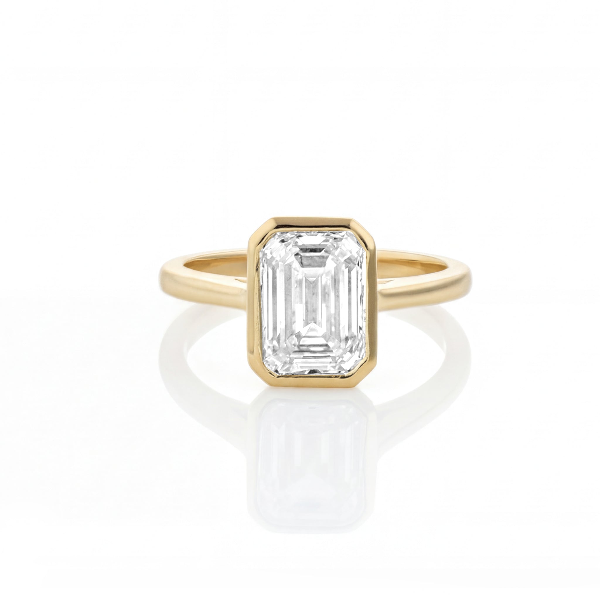 Bezel Set Emerald Cut Diamond Ring with a certificated diamond on a white background