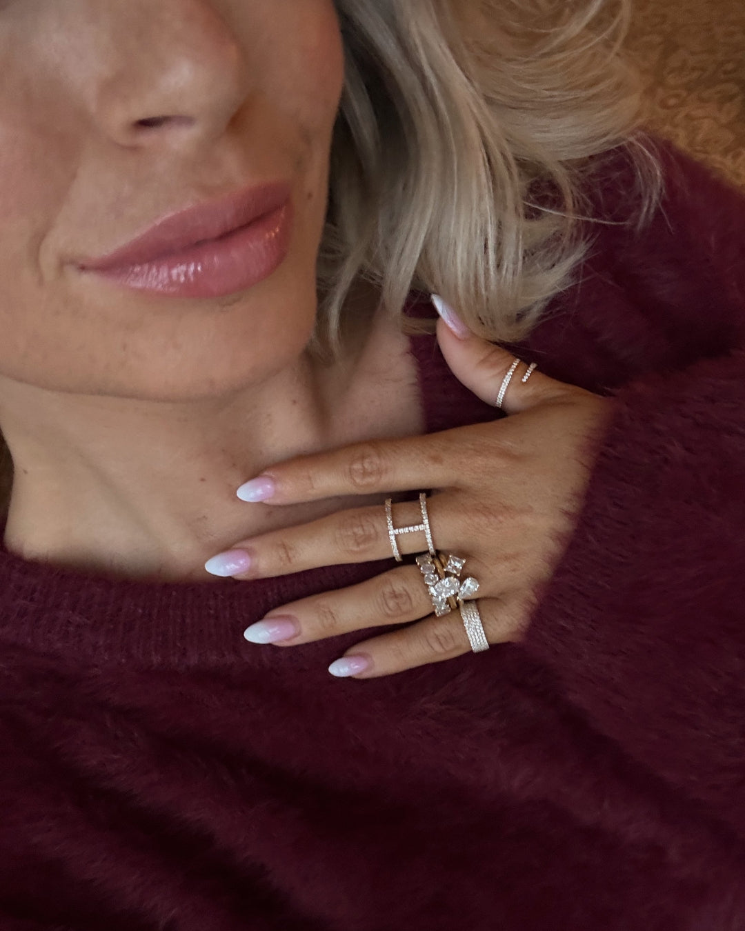 Close-up of a woman wearing multiple diamond rings on her fingers, showcasing modern luxury and style.
