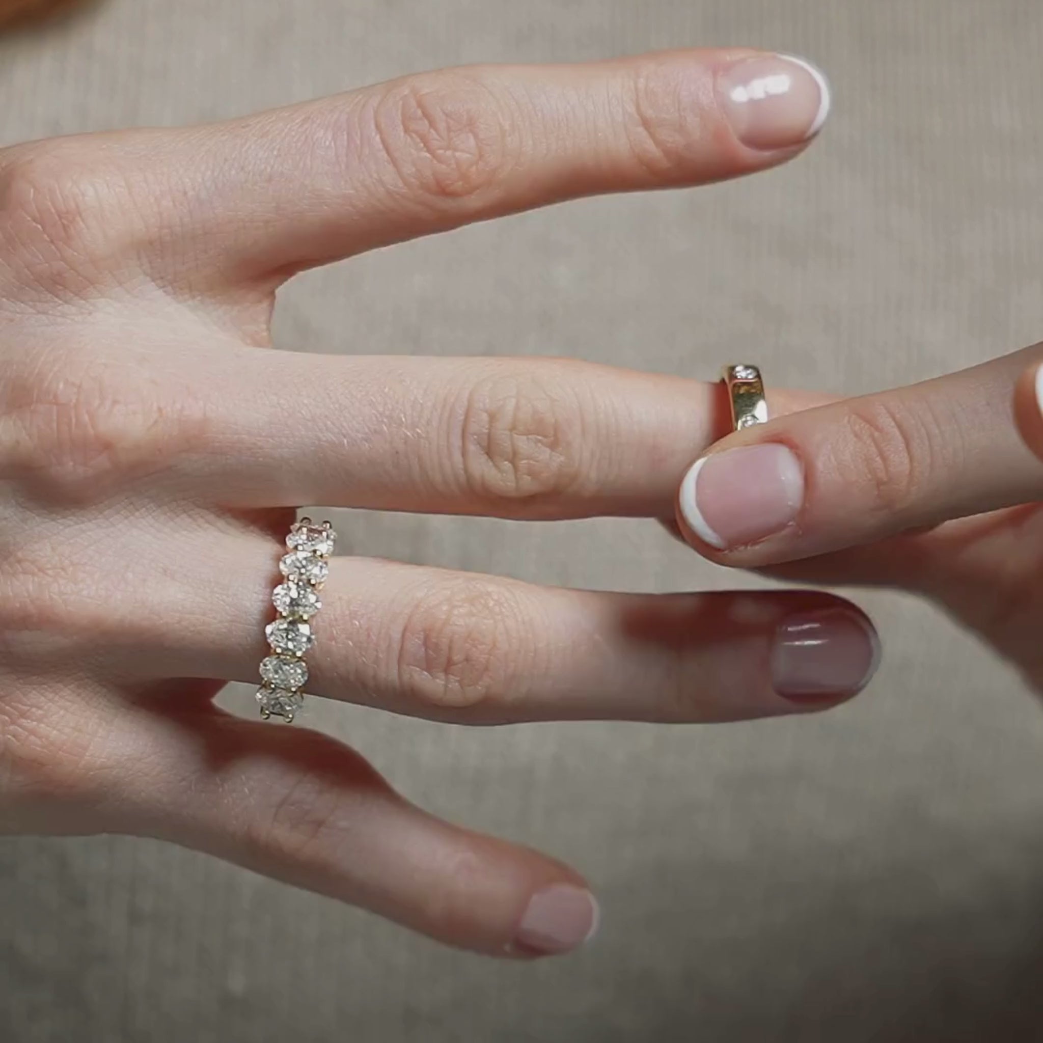 Close-up of a hand wearing a diamond eternity ring with intricate design and sparkle
