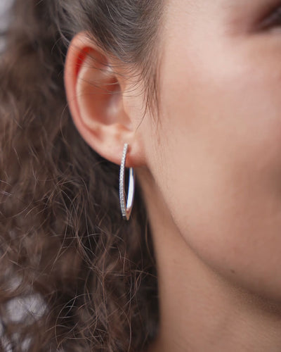 V-shaped certified diamond earrings in 18ct gold displayed on model's ear, highlighting elegant modern design.