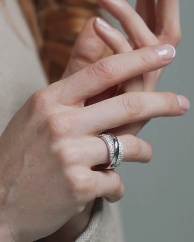 Close-up of a hand wearing a  certified diamond ring with intricate design and sparkle