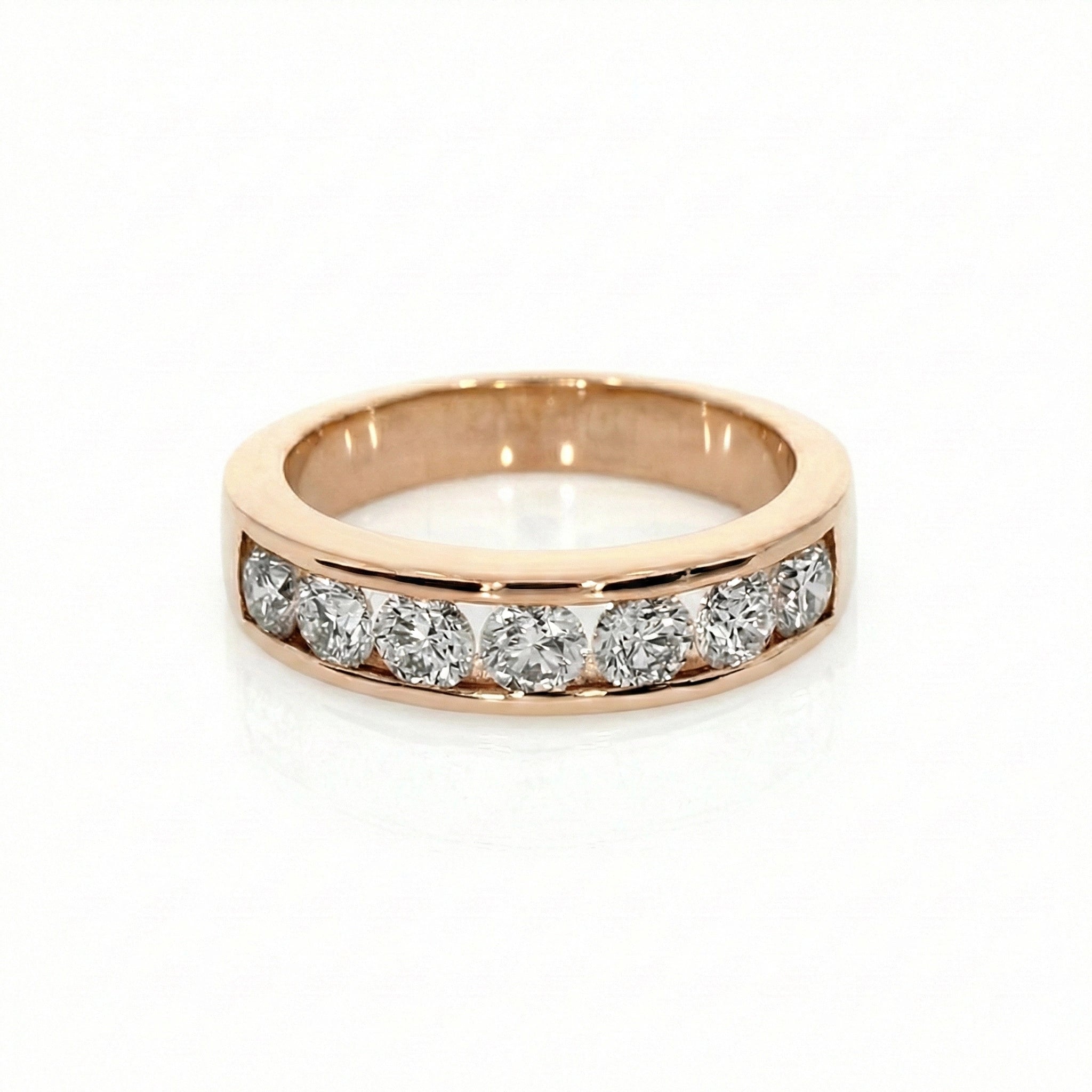 Round channel set diamond ring in rose gold featuring seven round brilliant diamonds in a modern channel setting.