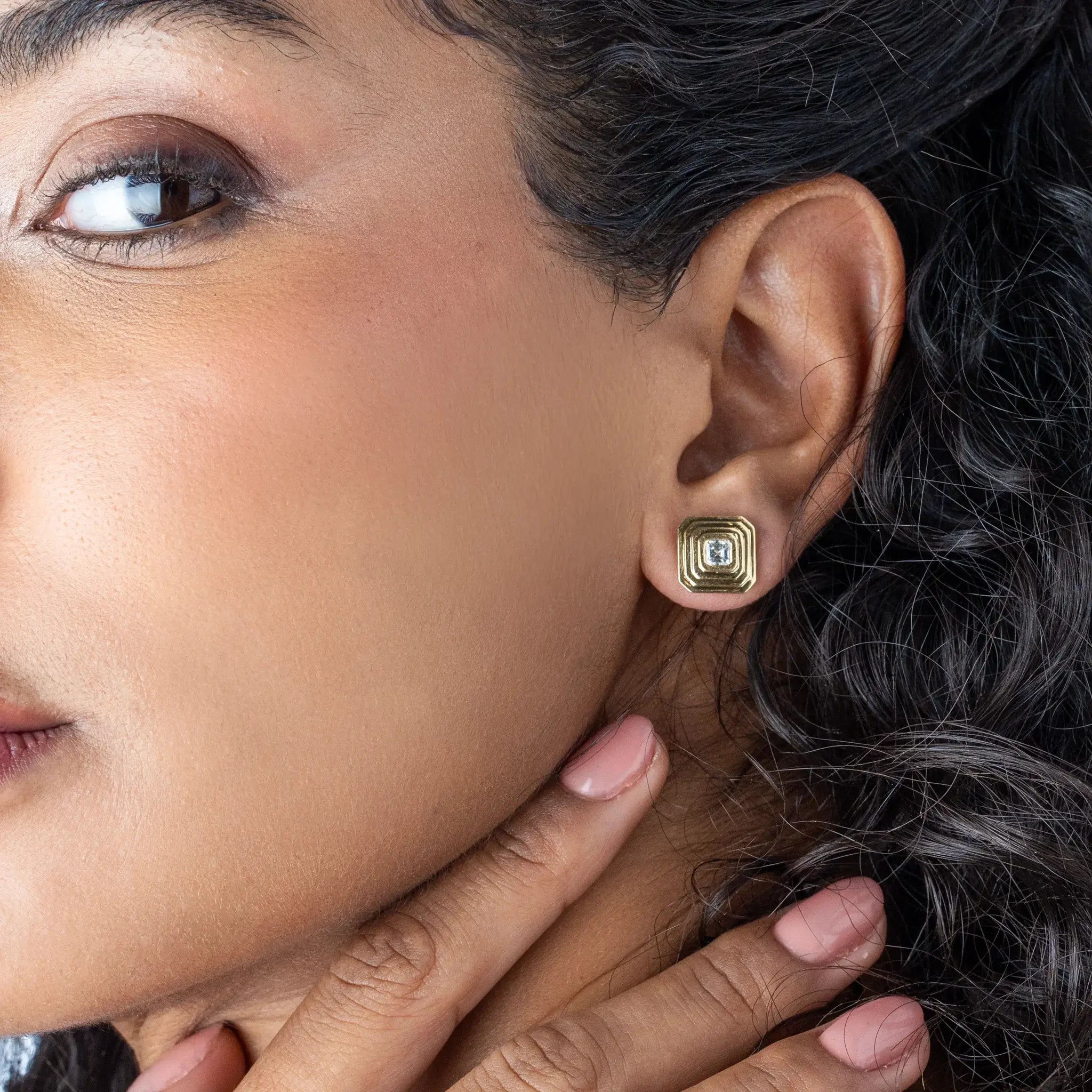 Model showcasing Tia Earrings - Large with Asscher cut diamond earrings in gold, highlighting sophisticated art deco style.